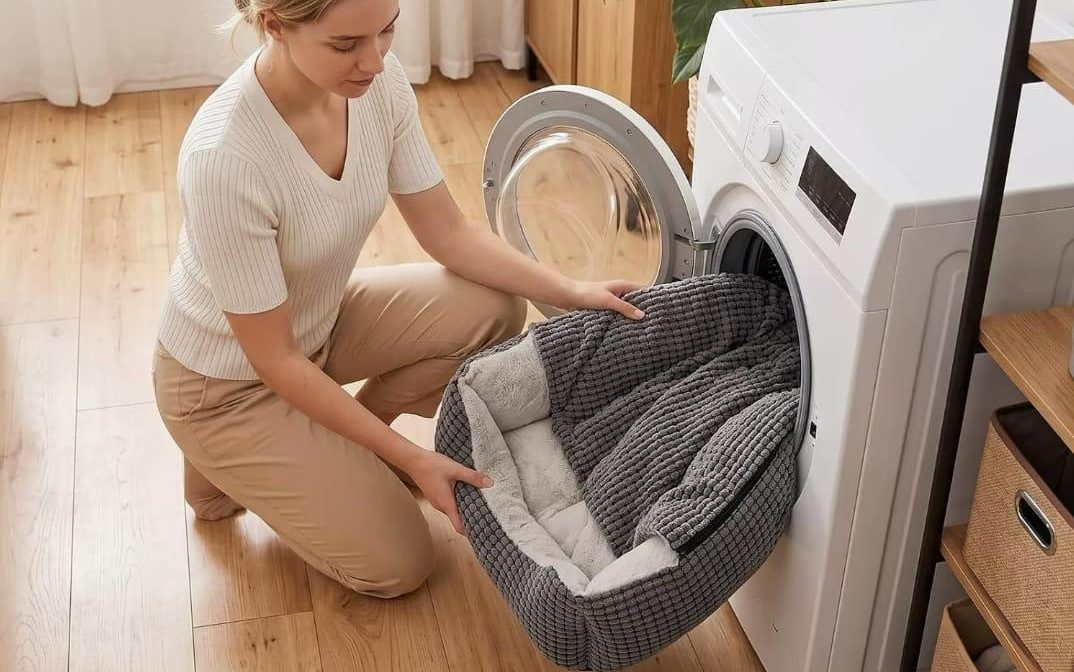 The whole bed being loaded into a front-loading washing machine by hand